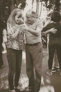 john-moeses-bauan-8YVaEljM-9I-unsplash (1) An older couple dancing outside a senior living community.