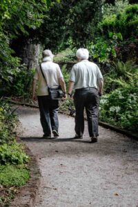 micheile-henderson–nn5ffUd6ZQ-unsplash Senior couple walking outside a senior living community.